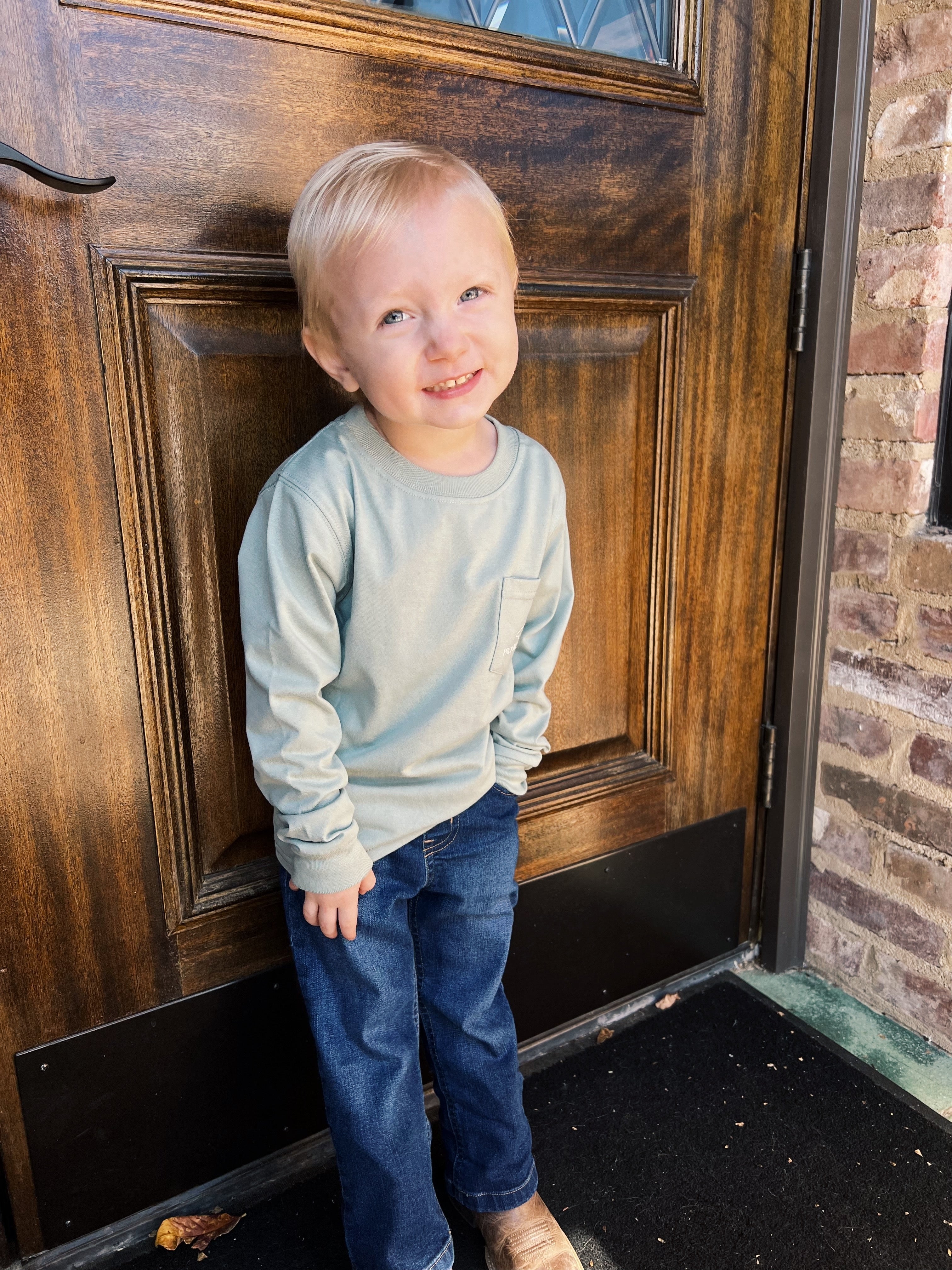 Image of a cute kid wearing a sweatshirt and jeans.